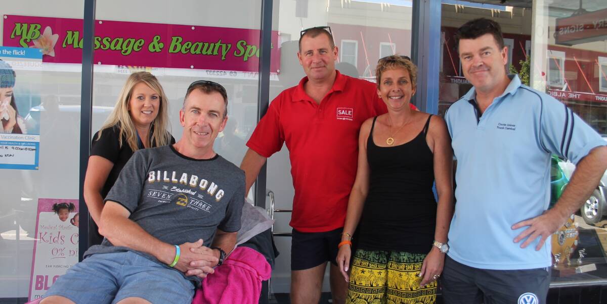 SET: Beauty therapist Belinda Freer (left) prepares to wax the legs of Stephen Howse (on the table), Paul Miller and Craig McTavish. The group is joined by Amanda Norman for whom the trio were fundraising. Picture: Jennette Lees