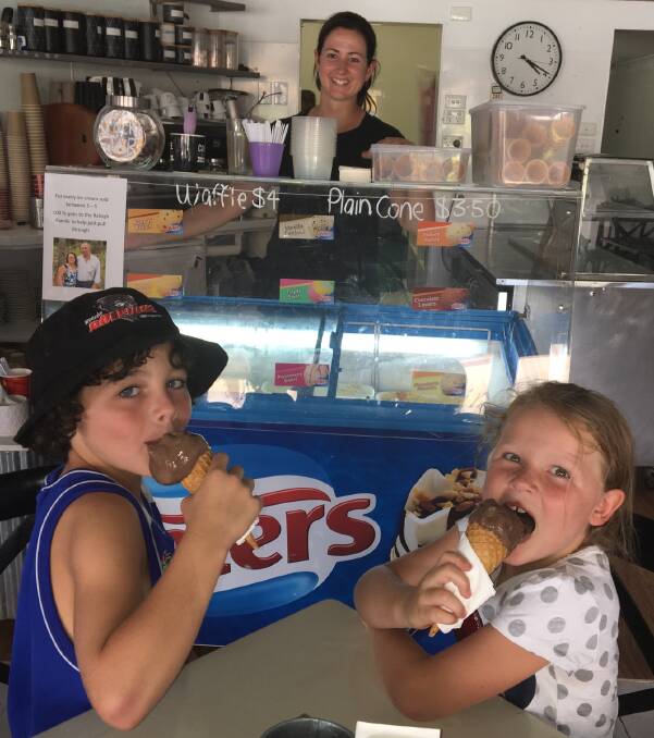 YUM: Jai and Shyla Willoughby with E'Claires owner Claire Berkrey in the background enjoy their ice cream during the Raleigh fundraiser hosted by the coffee shop.
