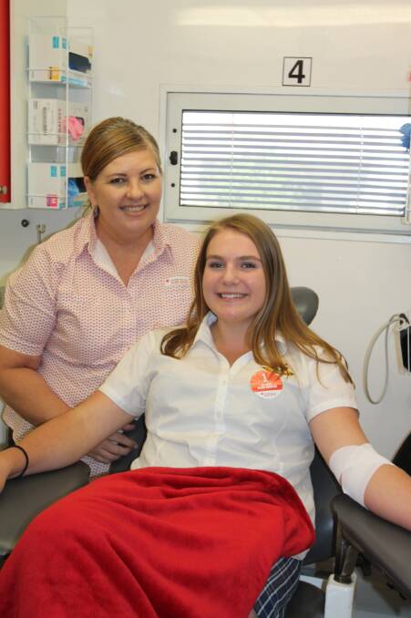 ROLL 'EM UP: Cootamundra High School student Kaede Nicka (right) with the Red Cross Blood Service staff during her first blood donation in March. Picture: Lachlan Grey