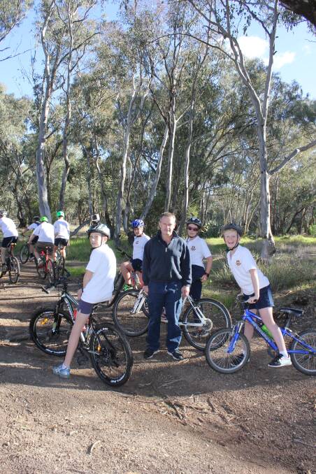 DOWN AND DIRTY: Cootamundra Cycle Club member Stephen Doidge checks out the upgraded track with Cootamundra High School's mountain bike elective students. Picture: CGRC