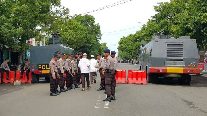 A blocked-off street and two water cannon trucks outside the court where Abu Bakar Bashir's trial is taking place in Cilacap, Indonesia. Photo: Amilia Rosa