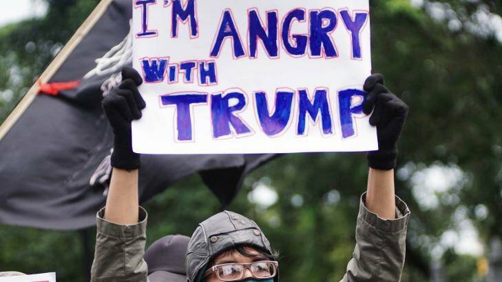 People hold placards during a protest against US President Donald Trump and his recent policies outside the American Embassy in Jakarta. Photo: Jefri Tarigan