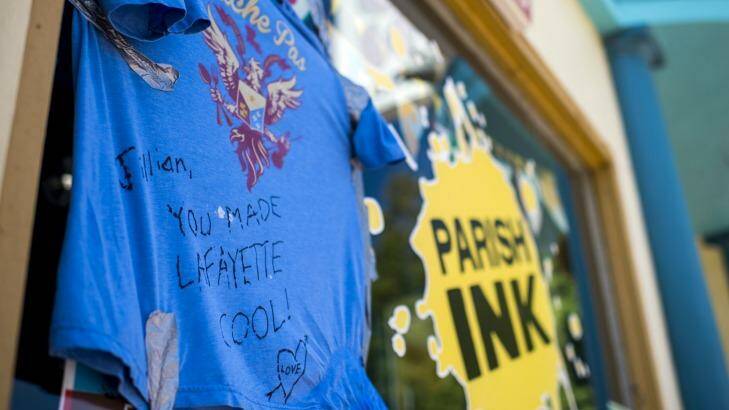 A shirt with a message dedicated to shooting victim Jillian Johnson hangs on the storefront window of Johnson's store Parish Ink in downtown Lafayette. Photo: The Daily Advertisers/AP