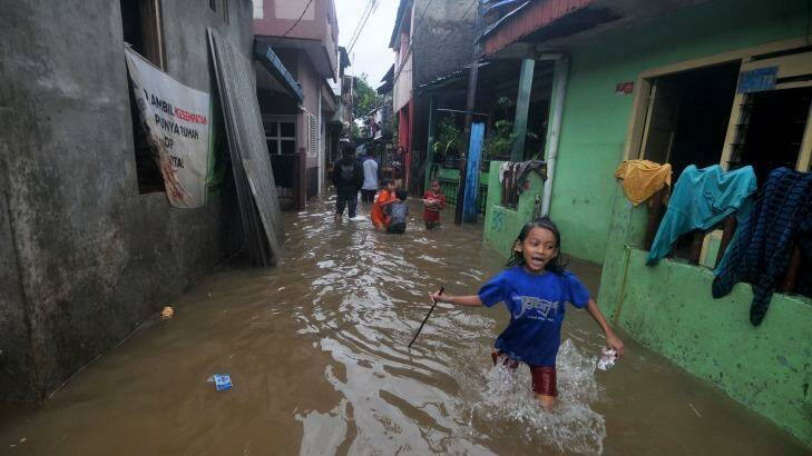 Children play on flooded streets after heavy monsoon rains in Bukit Duri, Jakarta, Indonesia on Tuesday. Photo: Jefri Tarigan 
