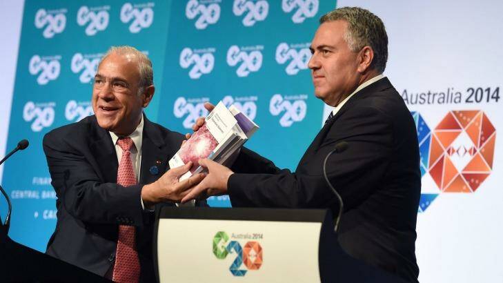 Treasurer Joe Hockey holds up a report with OECD secretary-general Angel Gurria (L) at the G20 Finance Ministers and Central Bank Governors Meeting in Cairns.