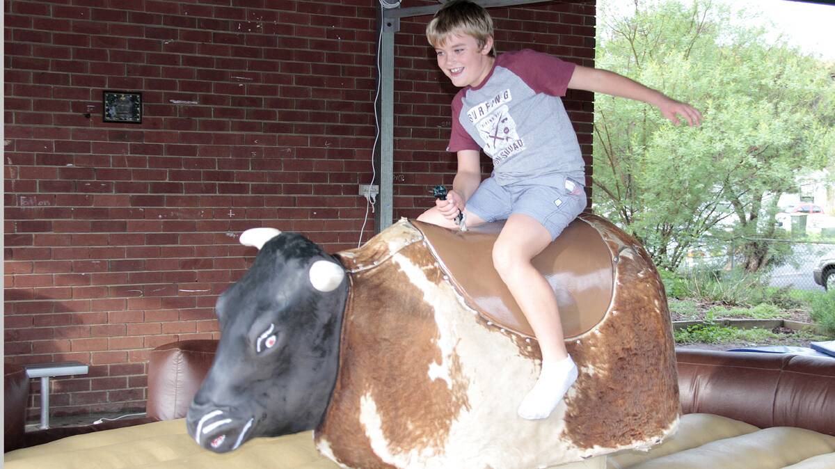 JUNIOR COWBOY: Charlie Howse takes his turn in the saddle of the mechanical bull at the Sacred Heart fete.