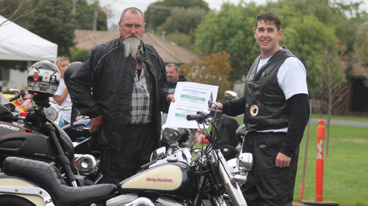  WITH THANKS: Cootamundra’s Robert ‘Loppy’ Longford hands over a generous donation from the GM Scott Social Club matched by GM Scott to Damien Holder, one of the organisers of Tubby’s Ride, held in town on Saturday. 
Photo: Melinda Chambers 