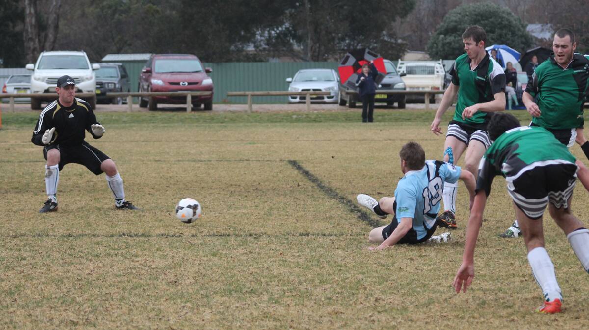  UNDER PRESSURE: Josh Purtell loses his footing but not his cool as he slots one home for the Strikers.