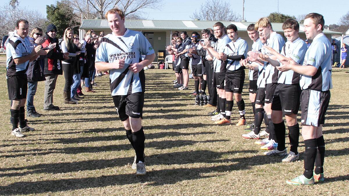 GUARD OF HONOUR: The Cootamundra Strikers cheered as Steve Armstrong ran onto the field. On July 26 he played his 150th game in Wagga Wagga, so the club held a guard of honour at home in Cootamundra last Sunday. 
Photo: Kelly Manwaring 