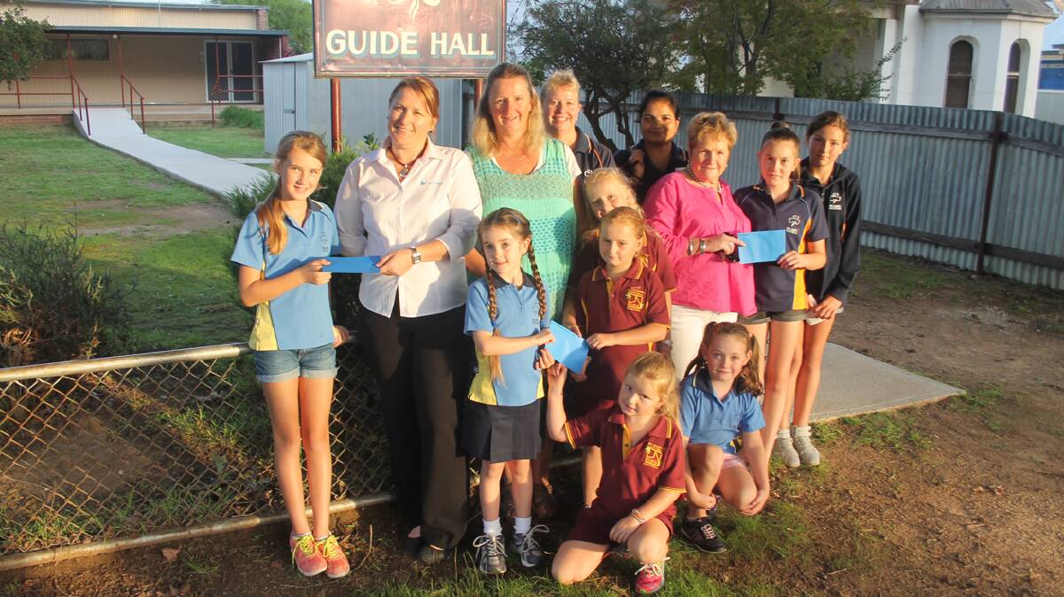 WITH THANKS: Pictured handing over funds from recent events where the Guides assisted are (back, from left) Jessalyn Wild, Sacred Heart P and F treasurer Jody Miller, Leanne Craw, Belinda Campbell, Neelan Agarwal, Southern Cross Care Retirement Village Auxiliary president Kate Longergan, Tahlia Morris and Georja Dowell (front) Chloe Willis, Tori Craw-Reid and Maddison Craw-Reid (kneeling) Mia Craw-Reid and Courtney James.  