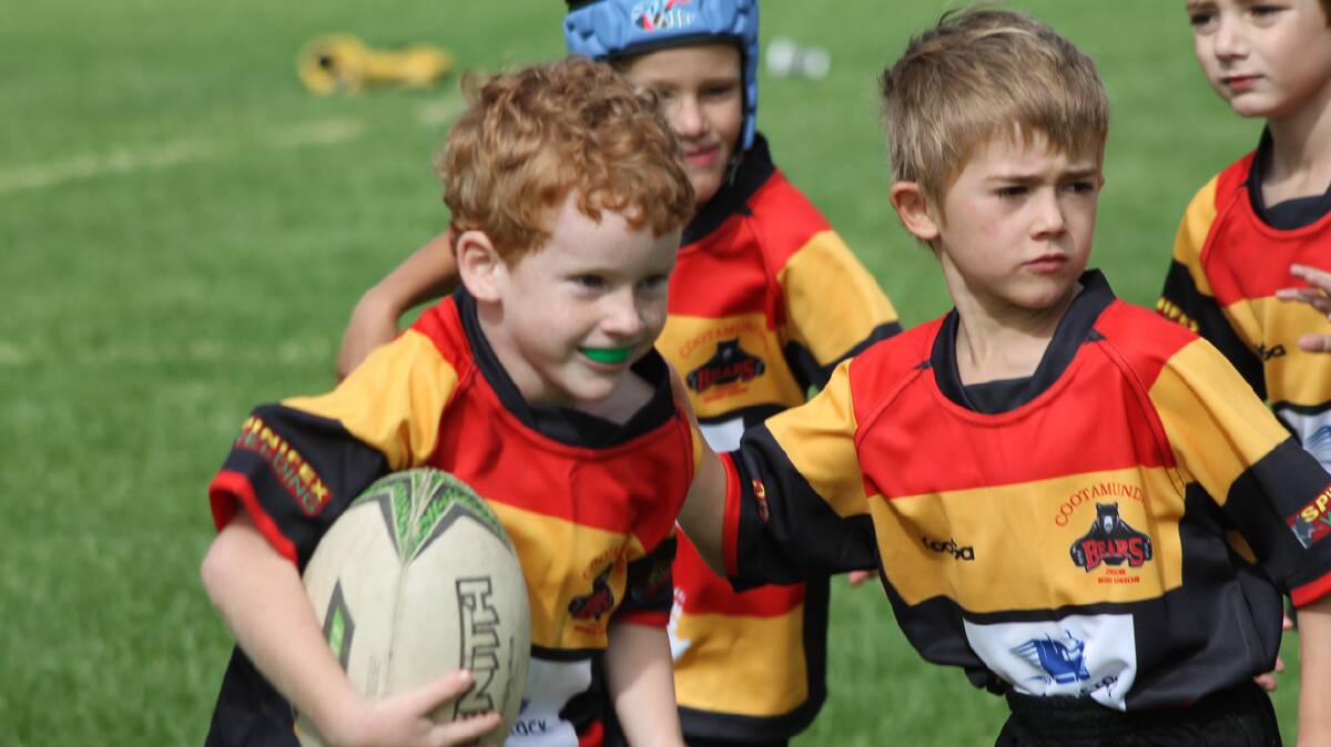 HAVING FUN: Cootamundra’s Squire Crawford (left) plays with a smile during the Cootamundra Junior Rugby Union Club’s Gala Day on Sunday while Dominic Shepherd adds his support.