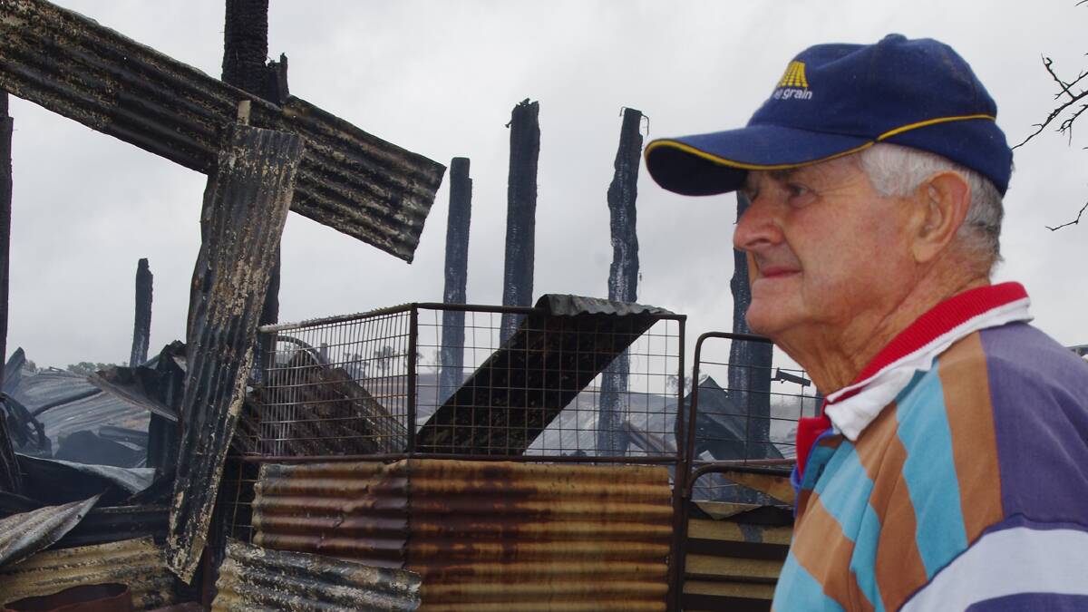 FIRE AND DAMAGE DONE: Geoff Larsen surveys the ruins of his shearing shed on Thursday morning. 