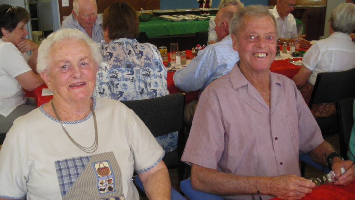 HAPPY FACES:  Shirley and Ian Armstrong were part of the Cootamundra Uniting Church group dining at the Stockinbingal Bowling Club last Sunday. About 55 people enjoyed an early Christmas lunch, with all the trimmings. Chosen to cut the celebratory cake was Audrey Ward, who plays the church organ for morning services on alternate Sundays.  Photo Contributed