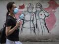 A resident wears a mask while passing the graffiti of nurses fighting against new coronavirus on June 16, 2020 in Wuhan, Hubei Province, China. Picture: Getty Images 
