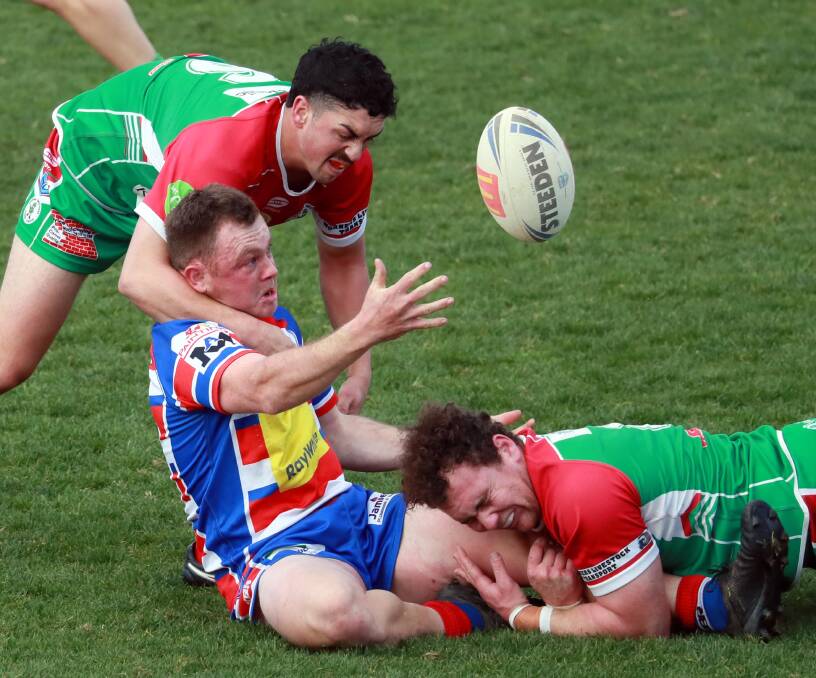 SECOND PHASE: Jesse Corcoran gets an offload away under pressure from Josh Siegwalt and James Hay in Young's win over Brothers on Sunday. Picture: Les Smith
