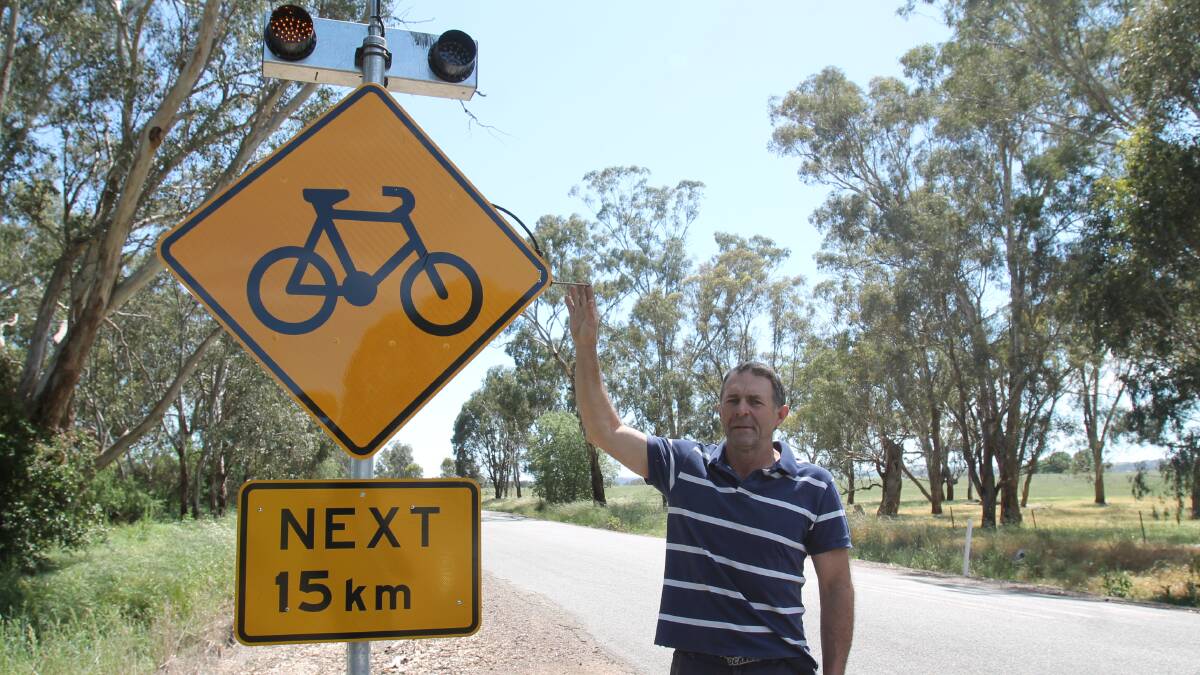 INNOVATION: Rod Holder demonstrates the new bicycle safety warning sign he has produced, and hopes to soon see around Cootamundra Shire. Picture: Harrison Vesey