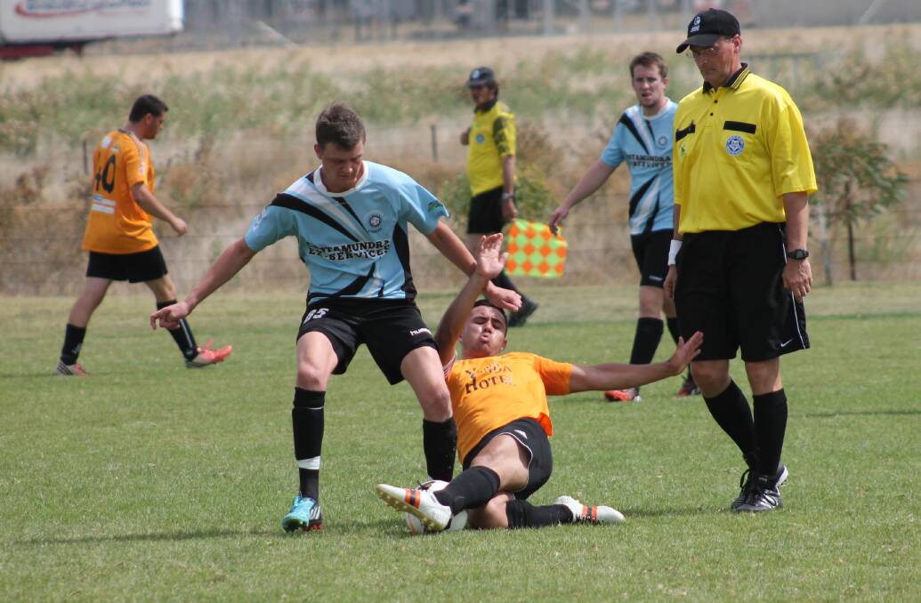 Football Wagga ref watches on, as Brenton Forsyth snatches the ball from Yenda's clutch. 