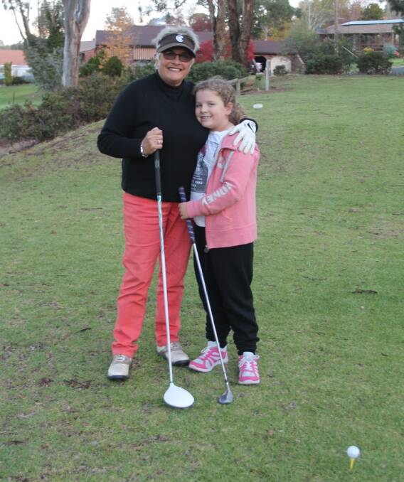 DAY ON THE GREEN: Local golfer Jenny Beath shows grandaughter Zoe the finer points of the game during a social round yesterday at the Cootamundra Course. 