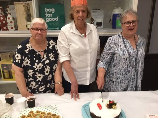 CELEBRATION TIME: Joyce Meale, Margot Gill and Ruth McCarthy cutting the Christmas cake at bridge this week. Picture: Contributed