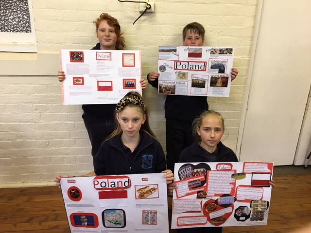 PROUD: Wallendbeen Public School students Chloe Anderson, Joshua Daly, Alicia Shepherd, and Marley Holder, proudly display their projects on Poland.