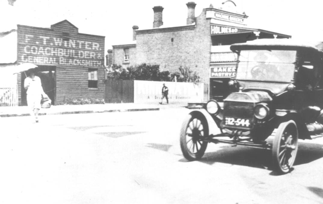 BUSINESS: Winter's Coach Builder, and the Holmes bakery stand behind an early model car in Cootamundra.