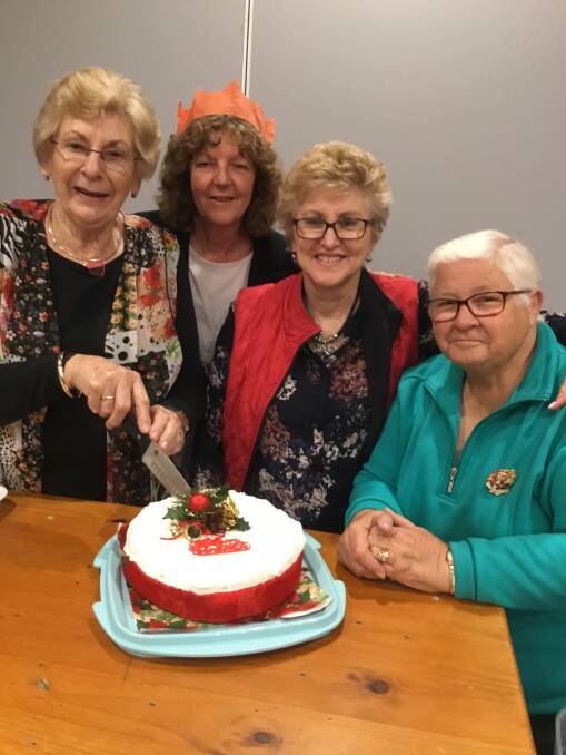 CELEBRATE: Sally Lawler cuts the cake with Julianne Collingridge, Lee Furness and Joyce Meale at the bridge. The Tuesday session will enjoy Christmas celebrations on December 19.  Picture: Contributed