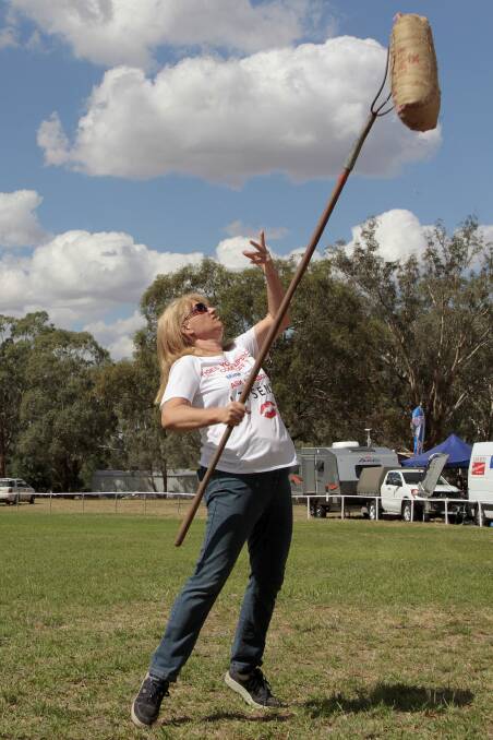 IN ACTION: Stockinbingal Village Fair committee member Wendy Millynn has a go at the sheaf tossing last year. Picture: Kelly Manwaring 