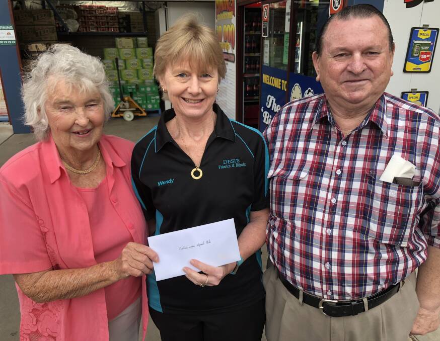 Big O bottleshop owner Lola Daley hands Wendy Bell of the Cootamundra Squash Club a cheque for $1000 while Keith Daley smiled at sharing their profits with the community. Picture: Kellie Hancock