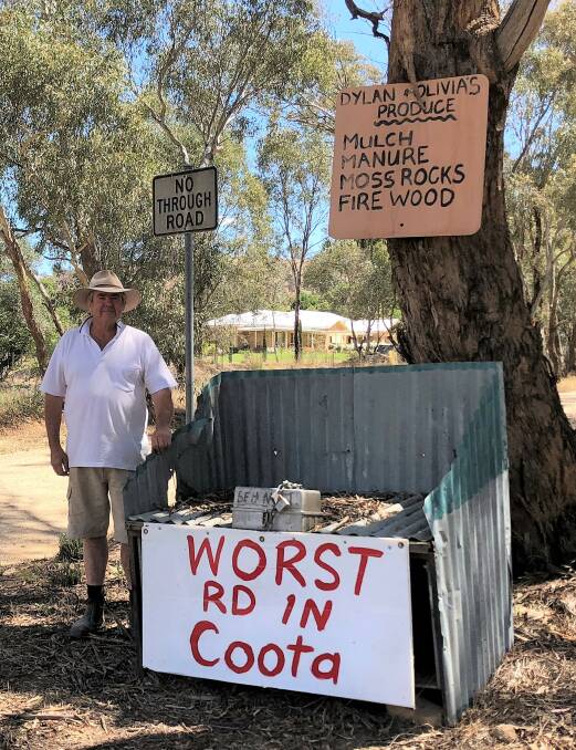 Warralong Road resident Robert Cram beside the sign erected on the corner of Boundary Road claiming 'worst road' status. Picture: Kellie Hancock