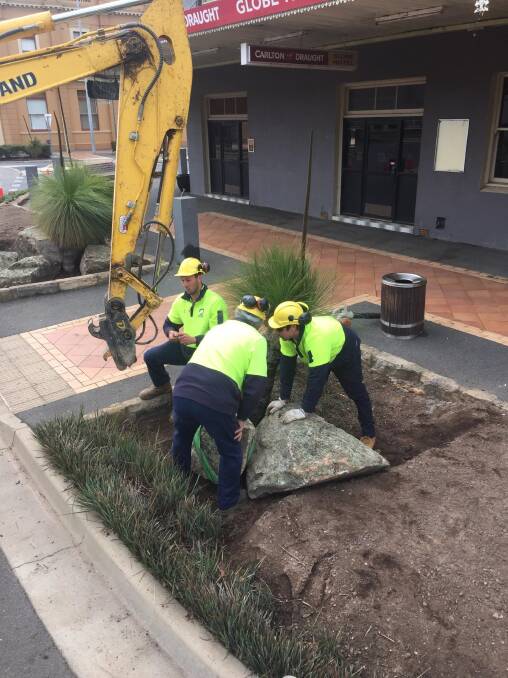ORNAMENTAL: Jacob Tiernan, Laurence Palmer and Will de Belin working on placement of ornamental rocks in the gardens in Parker Street.