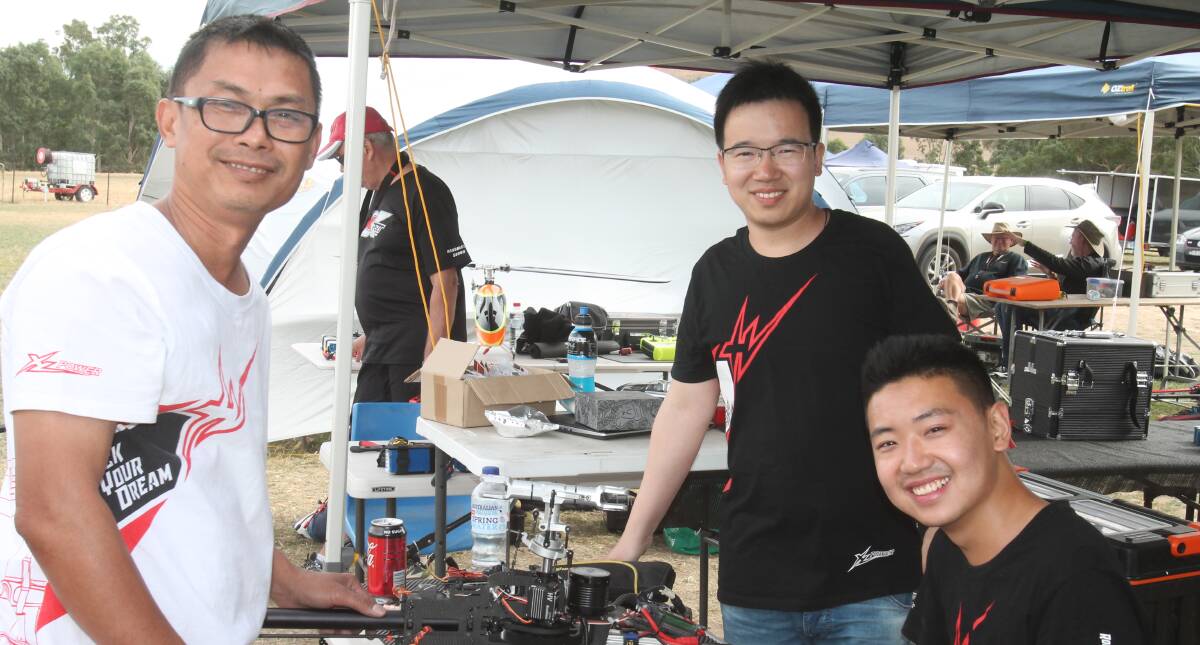 Champion pilot and expert on Thai-made XL models Kan Narong (right) helps repair a crashed model with Minfang Duan (left) and the owner Luo Kiawen. 