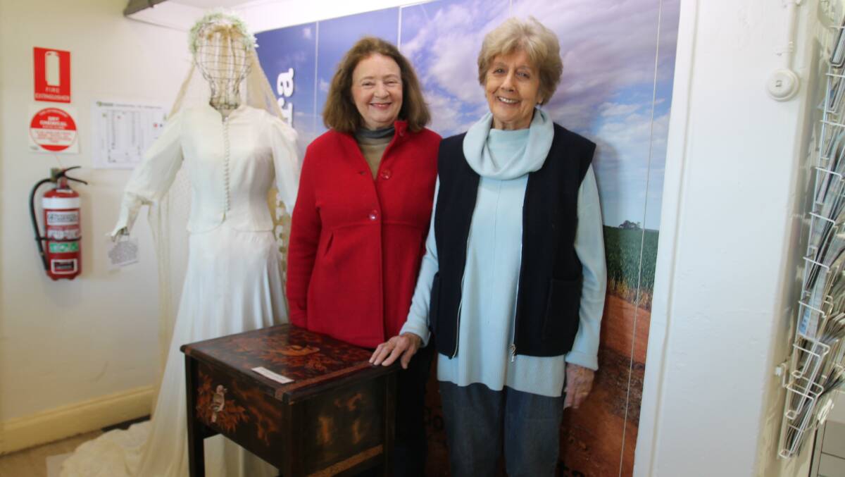Getting a new display ready for this weekend's 18th birthday celebration of the Heritage Centre, Rosalind Wight and Yvonne Forsyth with Edythe's sewing cabinet and a WWII wedding dress made in 1940 from parachute silk.