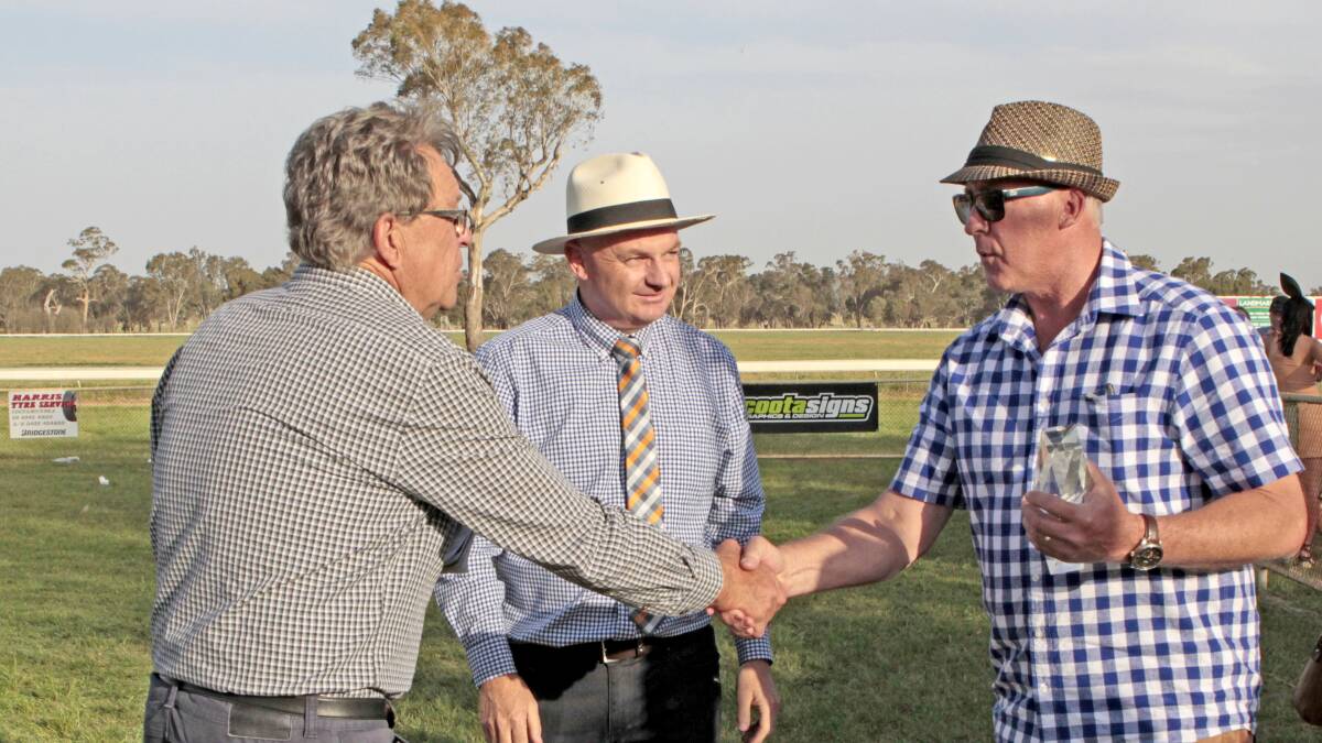 Turf Club committee member Gary Arhur (left) and president Brad Shields present the Cup to co-owner Adrian Grantham.