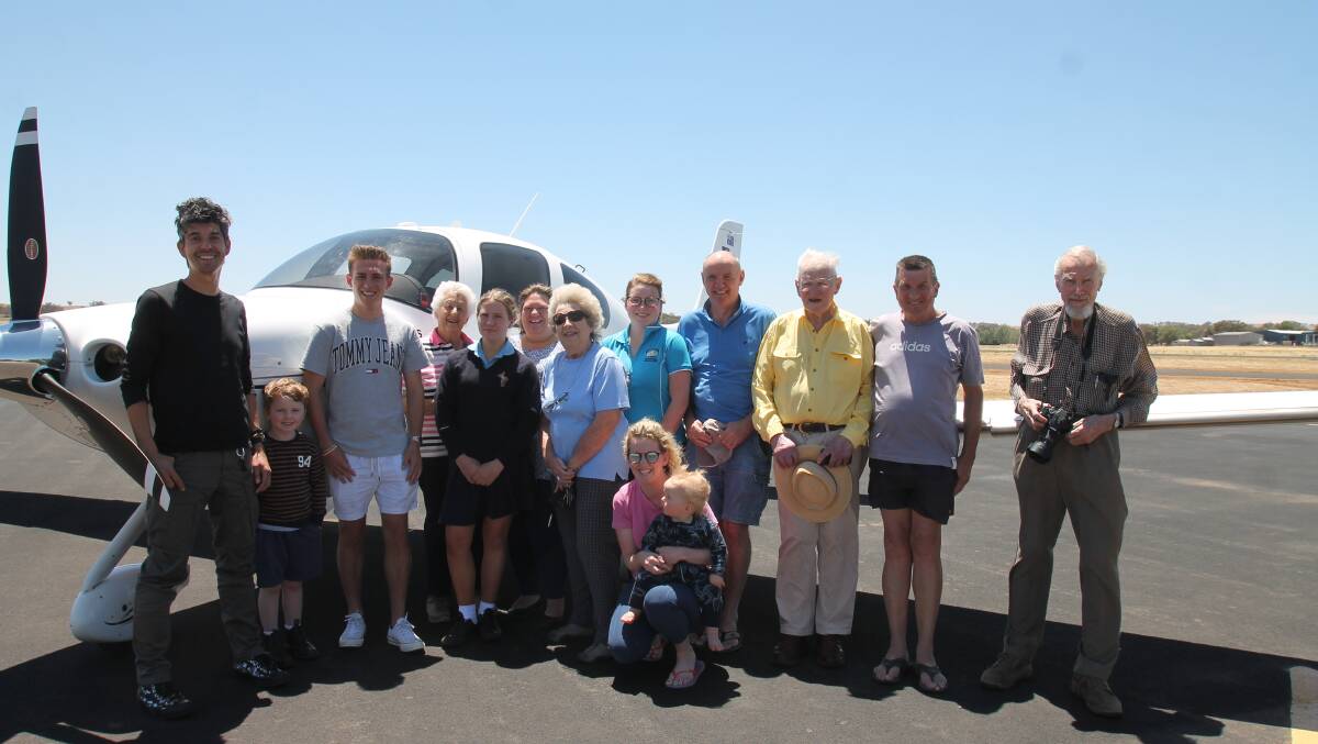 Stefan Drury (left) with Coota residents at the airport to welcome his historic re-enactment in his modern Cirrus SR22 single-engined craft. He had to circle and land on the grass runway to avoid strong cross-winds.