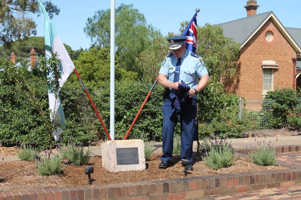 Commander of Riverina Police, Superintendent Bob Noble, unveils the Remembrance Day plaque.