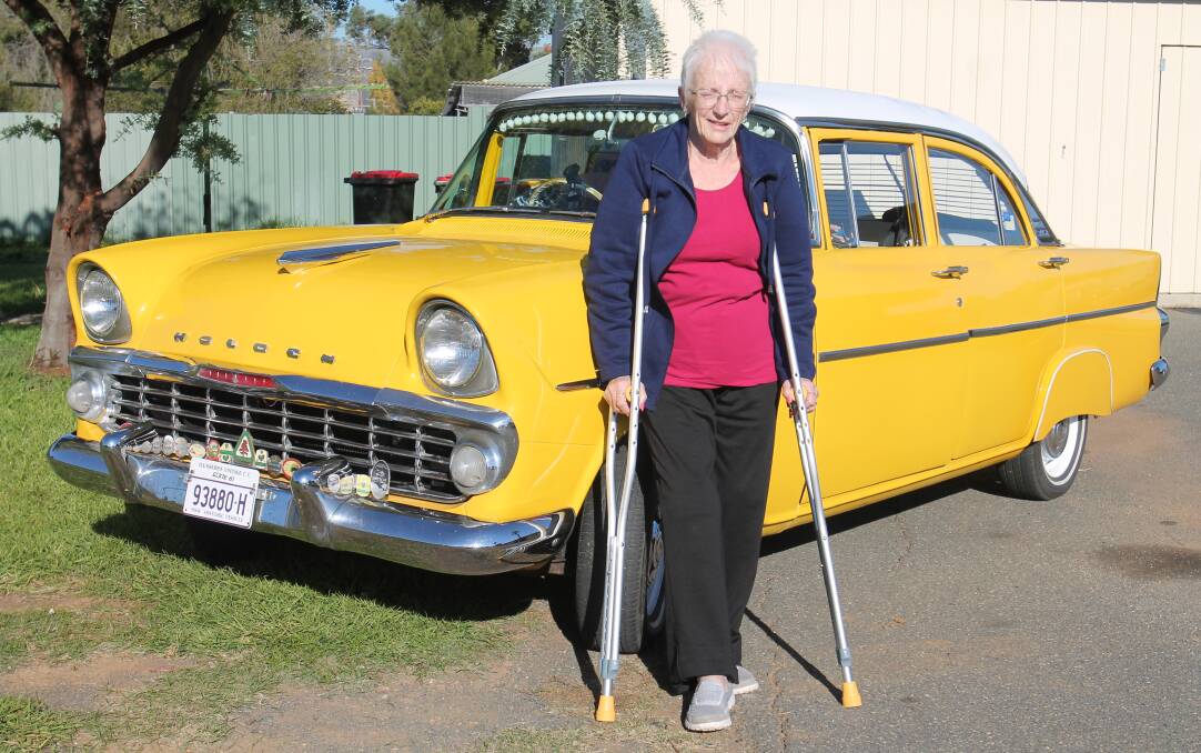 Injured: Irene Cox with one of the Illawarra cars, a 1961 EK Holden owned by Gordon Richardson of Albion Park Rail. The car was originally owned and restored by singer and TV star Angry Anderson, who raffled it for charity.