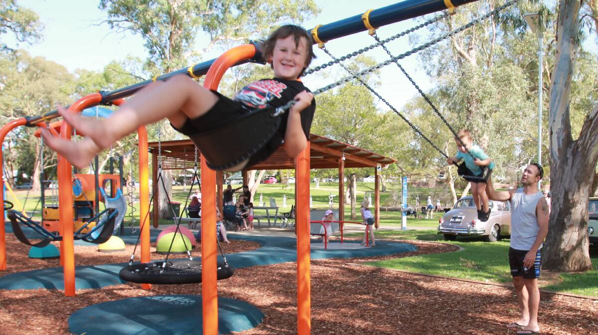 Malakhi Wilson at the top of his game with Grant Miller pushing son Levi, 3, on the swings at the new Jubilee Park playgound, proving immensely popular with Cootamundra kids.