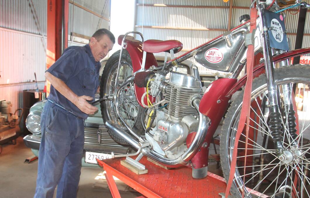 Mark Loiterton at work on a motobike, his hobby as well as being president of the (human-powered) Cycle Club and a member of the Aussie Rules committee.