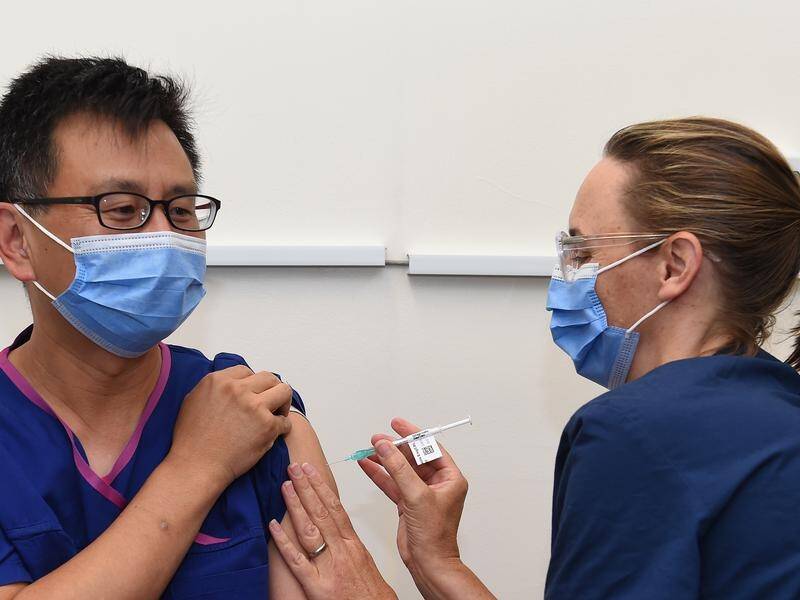 Victoria's Deputy Chief Health Officer Allen Cheng gets the Pfizer jab from nurse Karen Lasky.