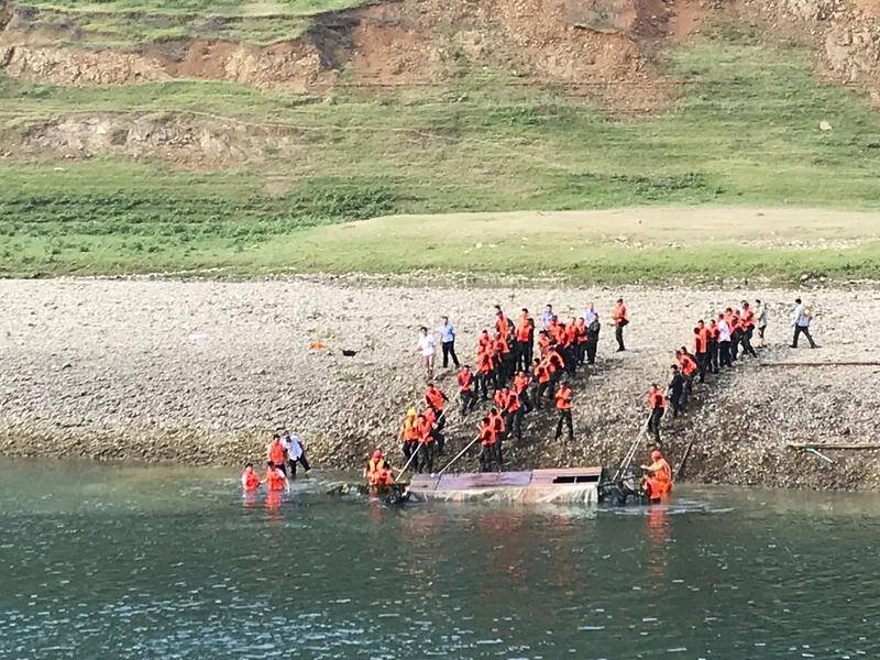 Rescuers lift a capsized boat from a river near Banrao village in southwest China's Guizhou province