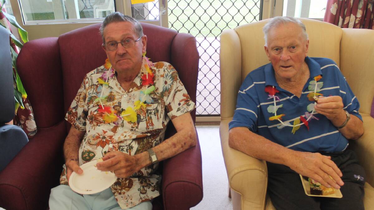  ENJOYING THE ATMOSPHERE: Cootamundra Nursing Home residents Bill Illingworth (left) and Tommy Pendergast enjoy afternoon tea at last Friday’s Trip to Hawaii function held as a fundraiser for the Internal Sprinkler System Appeal. Each of the residents were presented Hawaiian leis as part of the occasion. 
