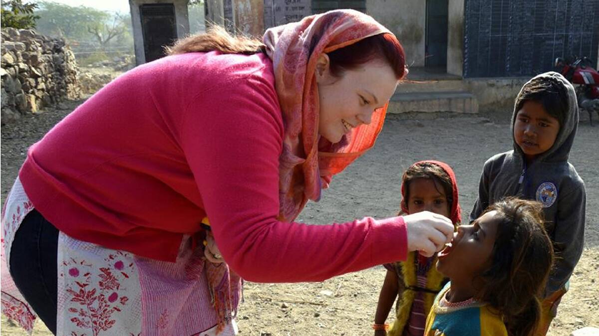  DOING HER BIT: Fiona Braybrooks administers two drops of polio vaccine to a child in India. 
Photo: Gaurav Bansal