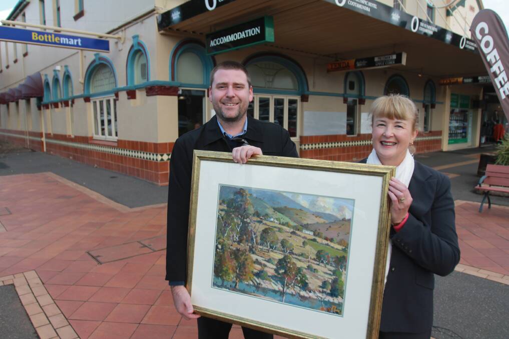 MURRUMBIDGEE COUNTRY: Adam Barnes and Wendy Slater hold the prize in a raffle - a Alan McClure original oil painting. Photo: Declan Rurenga