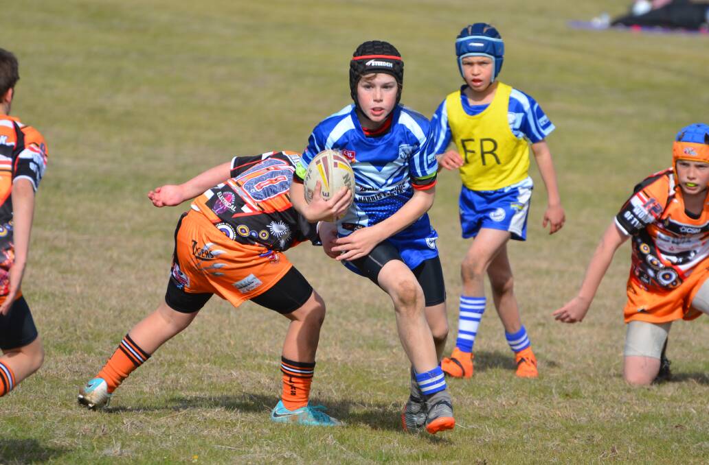 Ned Murray looks to break out of a tackle at the Riverina Schoolboys Carnival. On Saturday, the under 11s will play Young for a chance to score a grand final place. Photo: Declan Rurenga