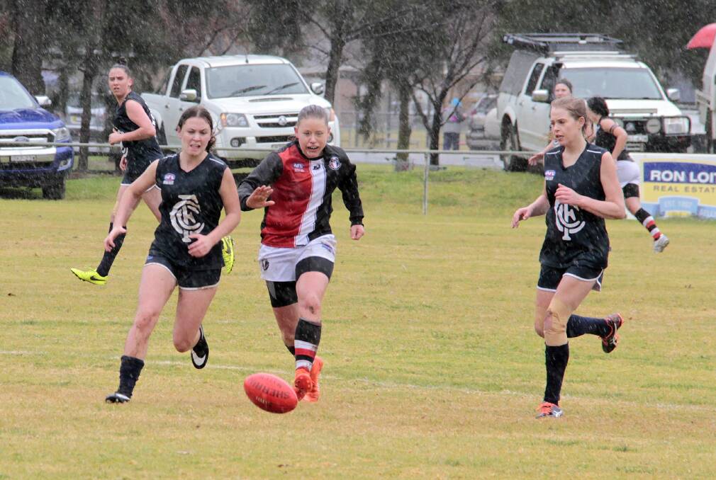 CHASE: Emily Poulton and an Ainslie player race to regain possession at Clarke Oval on Saturday. Photo: Kelly Manwaring