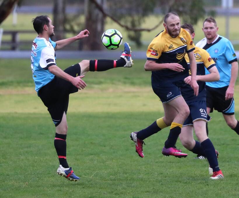UP AND OVER: Derek Krogh clears the ball for Cootamundra under pressure from Junee's Jade Becroft during last weekend's match at Burns Park. Krogh will miss this week's game against Henwood Park. Photo: Les Smith