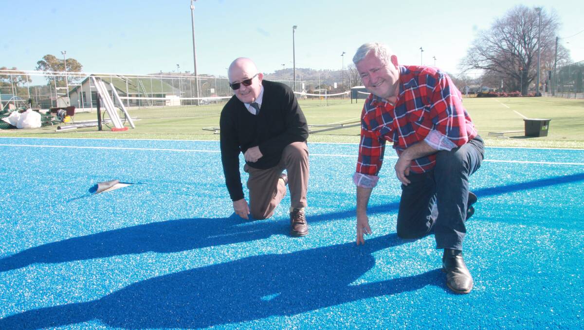 CLOSER INSPECTION: Cootamundra-Gundagai Council's general manager Allen Dwyer and tennis club president Garrie Cooper inspect the new surface on one of six courts that has been upgraded. Photo: Declan Rurenga